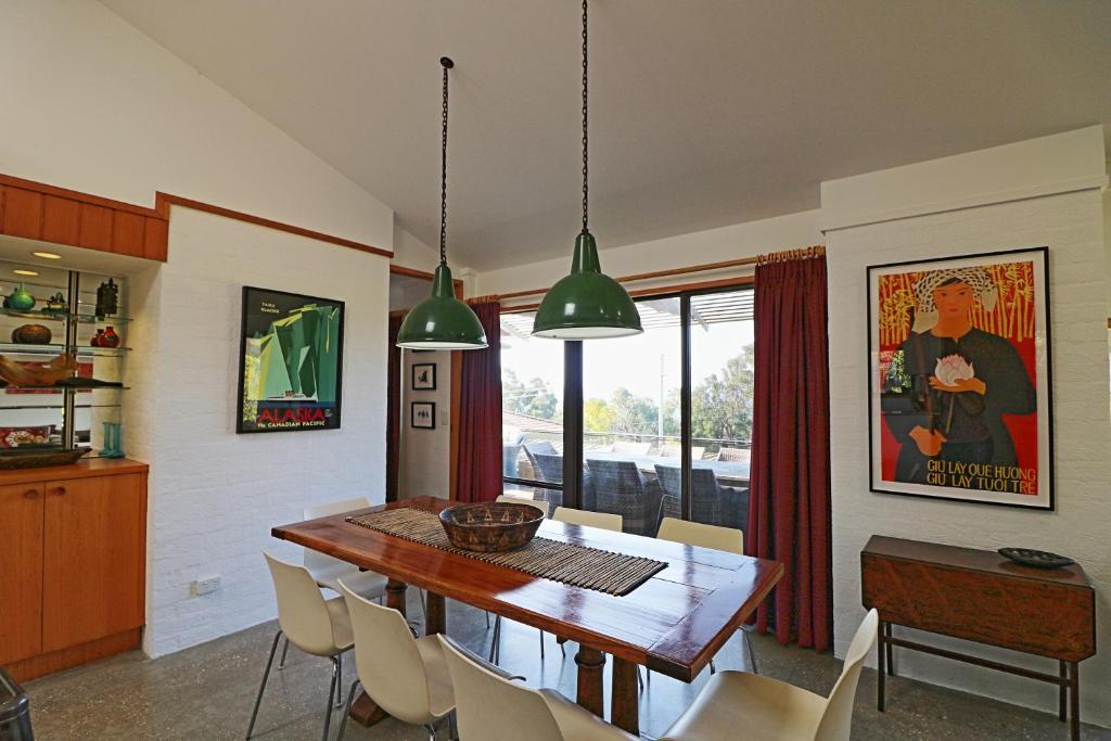 a dining room with a wooden table and chairs at Seavista 2 in Pambula Beach