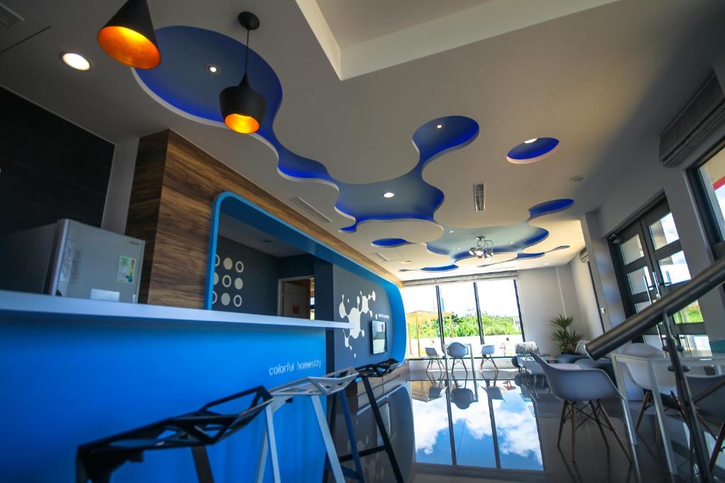 a room with a bar with chairs and blue ceilings at Colorful Homestay in Magong