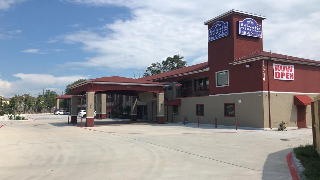 a building with a sign that reads new open at Atlantis Inn Suites in Houston