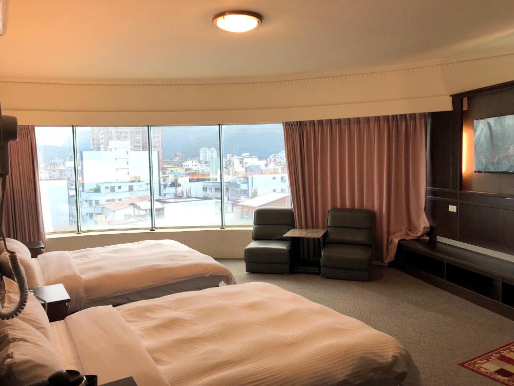Habitación de hotel con 2 camas y ventana grande. en 奇萊大飯店 Chuline Hotel, en Hualien City