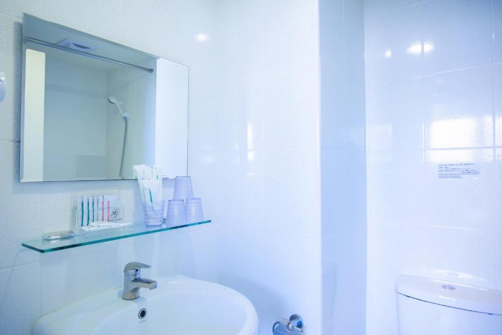 a white bathroom with a sink and a mirror at Green World Sansui in Taipei