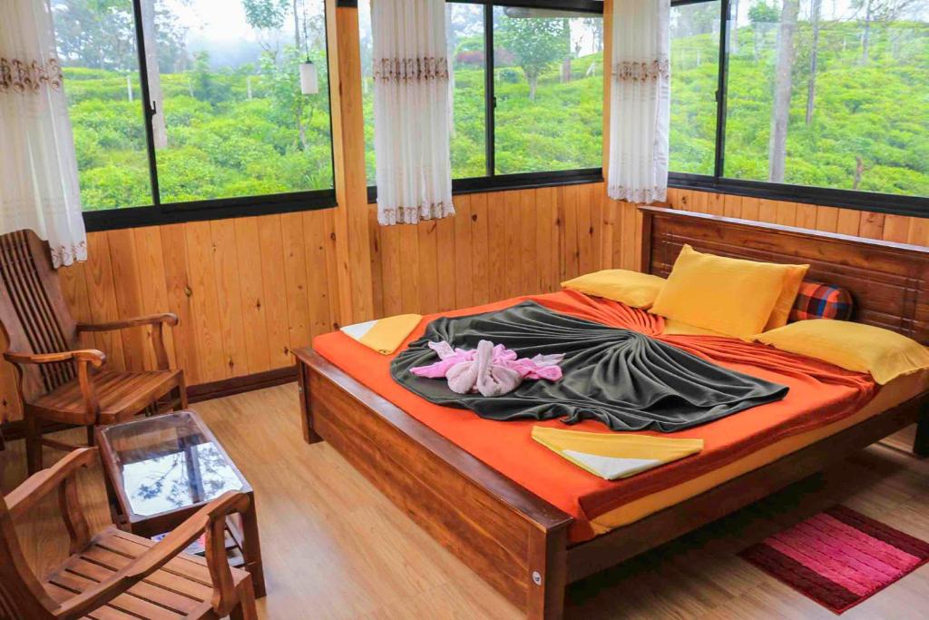 1 dormitorio con 1 cama grande en una habitación con ventanas en Tea Forest Lodge, en Ella