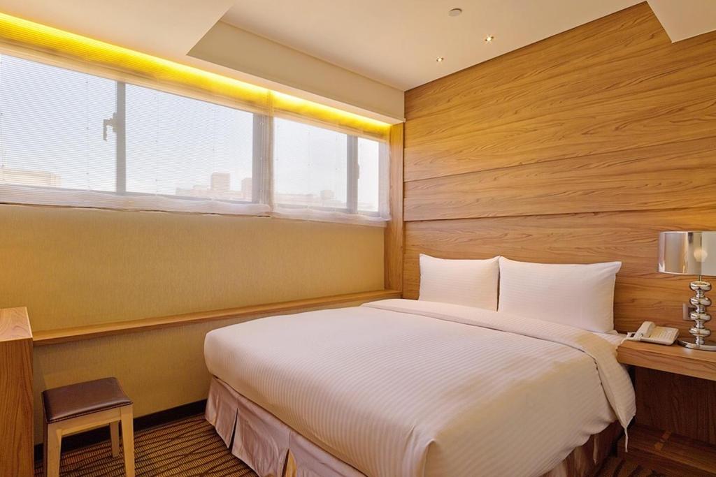 a bedroom with a large bed and a desk and window at Green World Sansui in Taipei
