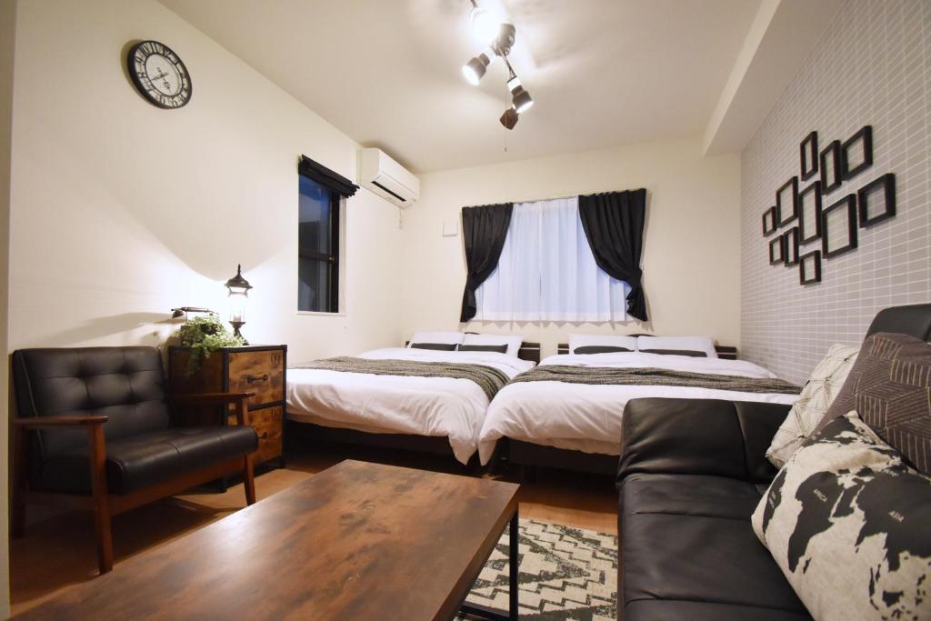 a living room with two beds and a couch at Origami Residential Suite - Tokyo Asakusa Skytree in Tokyo