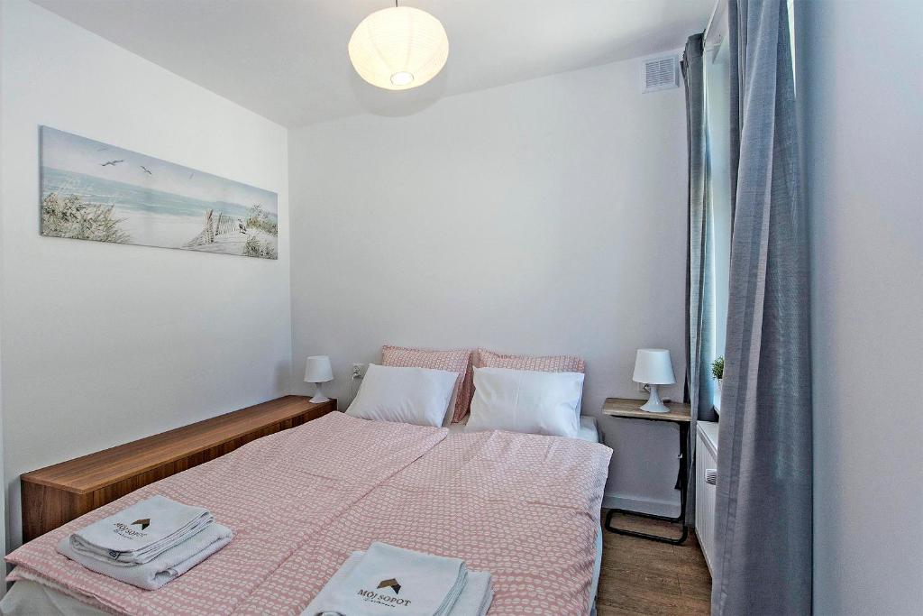 niewielka sypialnia z łóżkiem i różowym kocem w obiekcie Promenada moj-sopot pl w mieście Sopot