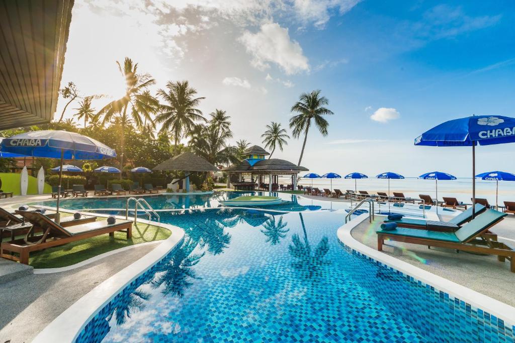 查汶的住宿－查博卡巴娜海灘度假村，度假酒店的游泳池配有椅子和遮阳伞