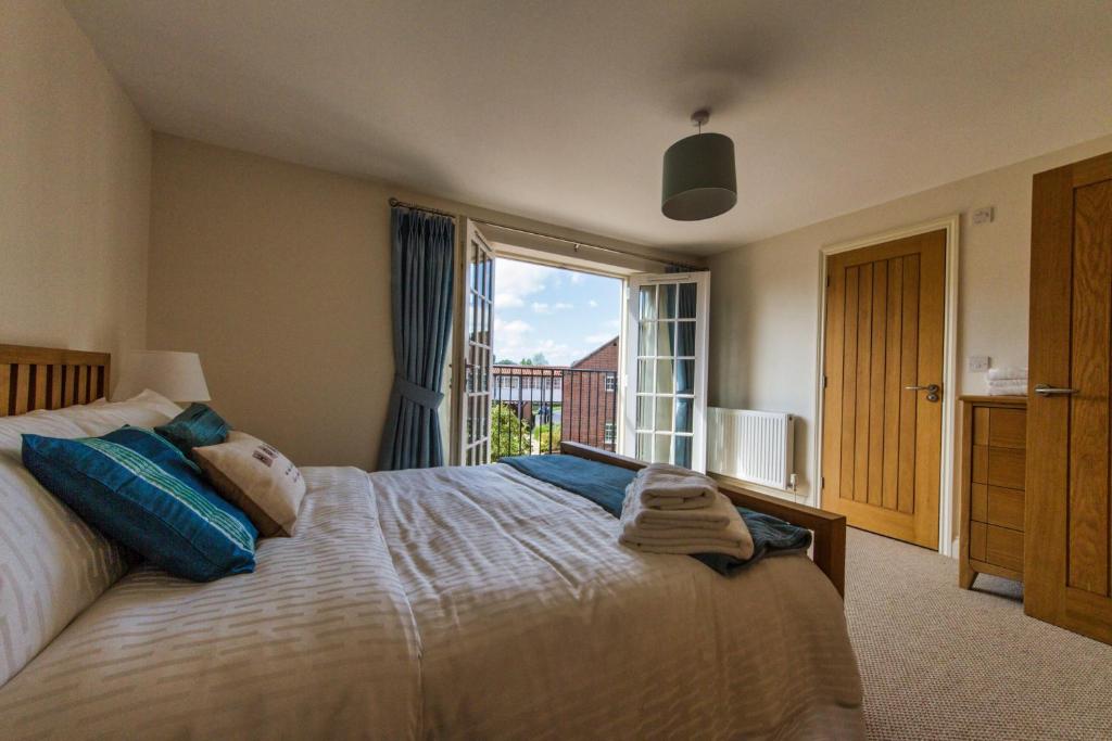 a bedroom with a large bed with a large window at Broads Reach in Stalham