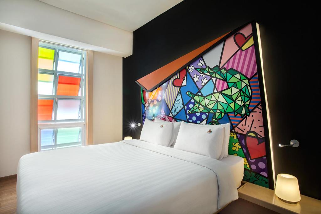 a bedroom with a white bed with a stained glass window at MaxOneHotels.com at Tidar in Surabaya