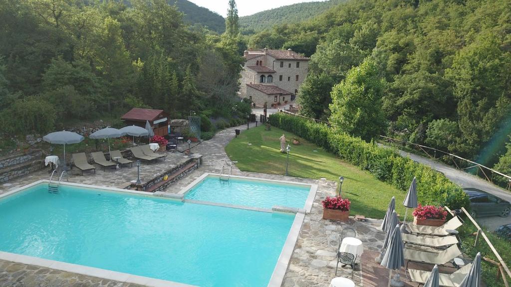 vista para uma piscina em frente a um edifício em Hotel Le Pozze Di Lecchi em Gaiole in Chianti