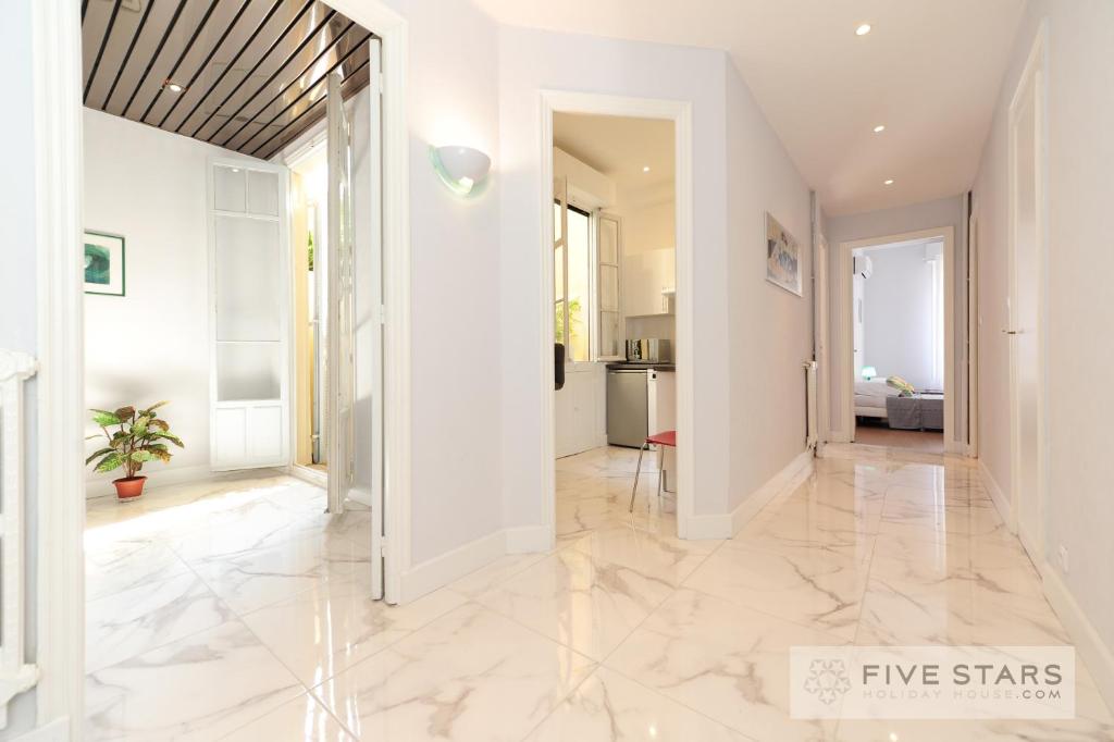 a hallway with white walls and marble flooring at Suite Gioia five stars holiday house in Nice