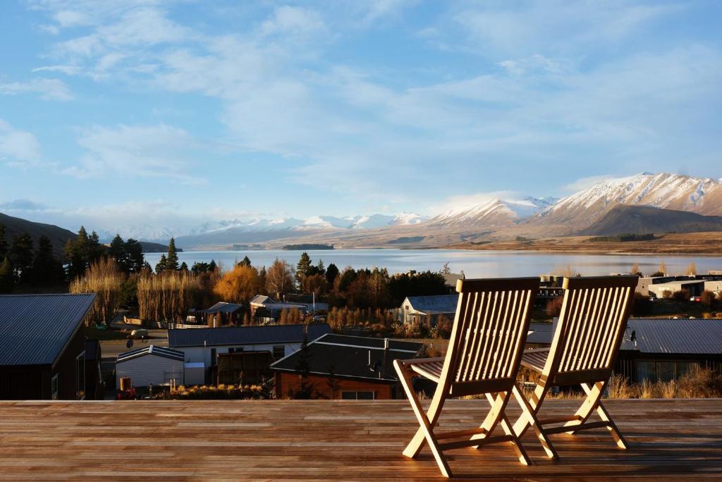 two chairs sitting on a deck with a view of a city at The View Lake Tekapo in Lake Tekapo