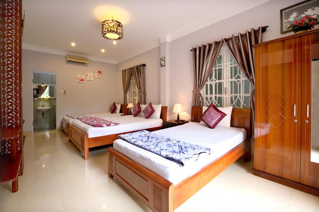 1 dormitorio con 2 camas y ventana en Green Garden Homestay, en Hoi An