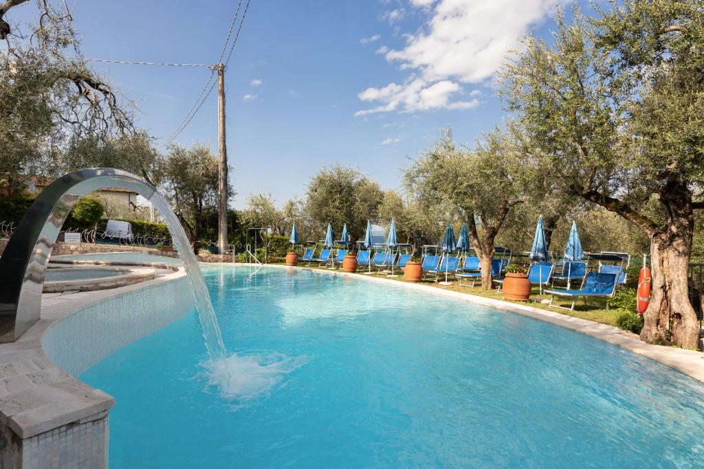 a pool with a water fountain in the middle at Hotel Internazionale in Torri del Benaco
