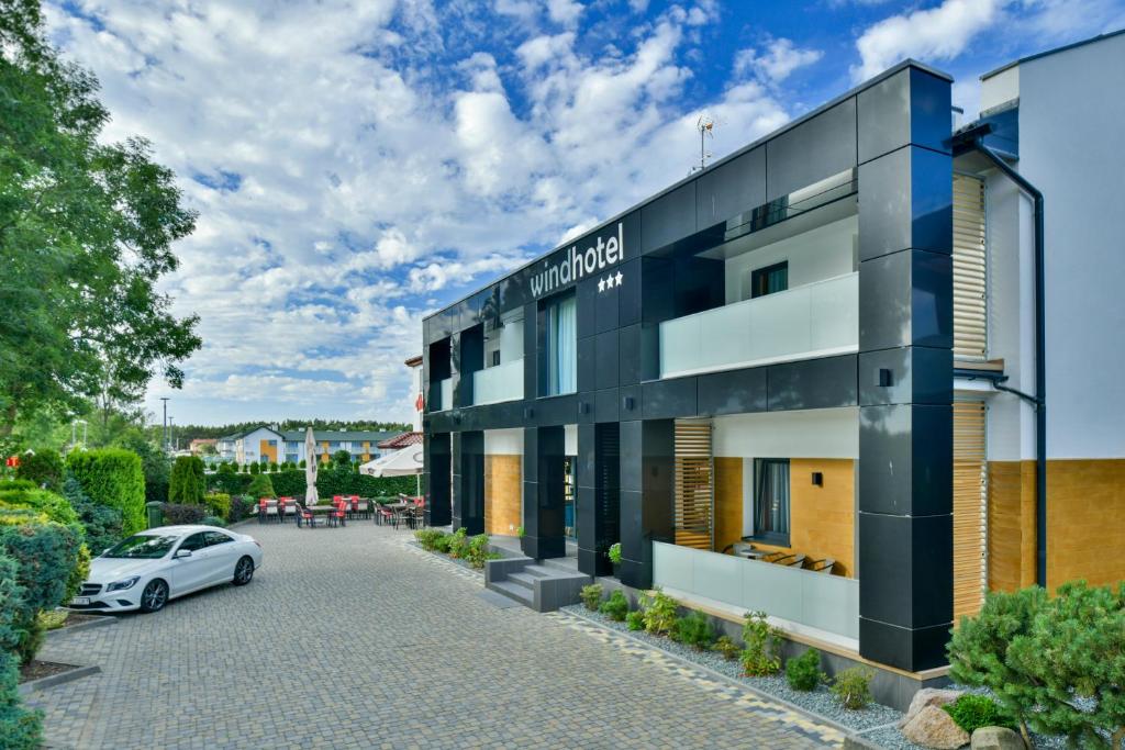 a white car parked in front of a building at WIND Hotel in Grzybowo