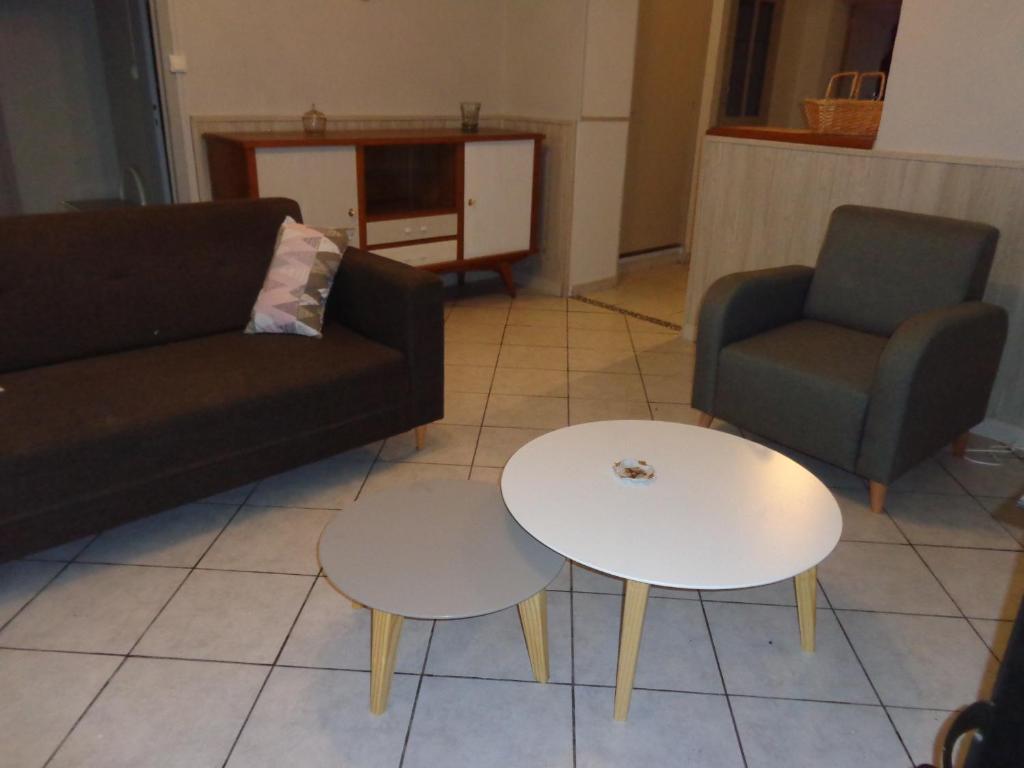 - un salon avec un canapé et deux tables dans l'établissement 34 Rue de la Coucouroune Gîte de la Coucouroune, à Soual