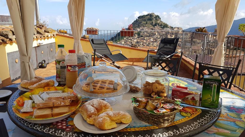 una mesa con platos de comida en el balcón en Heart Of Sicily en Mistretta