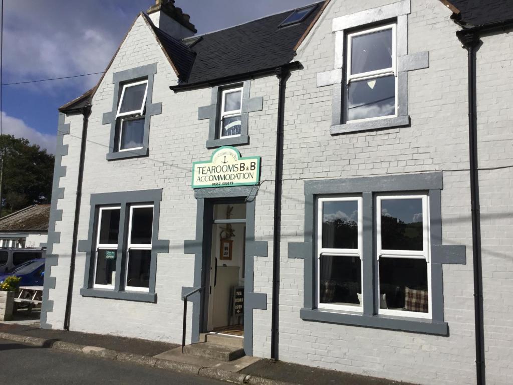 a white building with a sign above the door at Crown and Anchor in Dundrennan