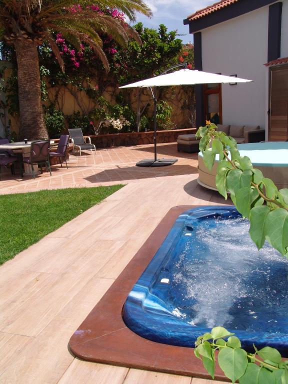 a swimming pool in a yard with an umbrella at Villa Beatriz in Salobre