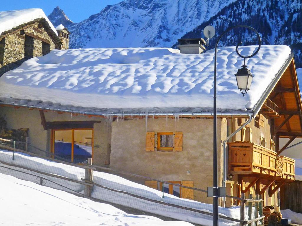 ein Haus mit einem schneebedeckten Dach mit Straßenbeleuchtung in der Unterkunft Pretty Chalet with Sauna Skiing Nearby in Peisey-Nancroix