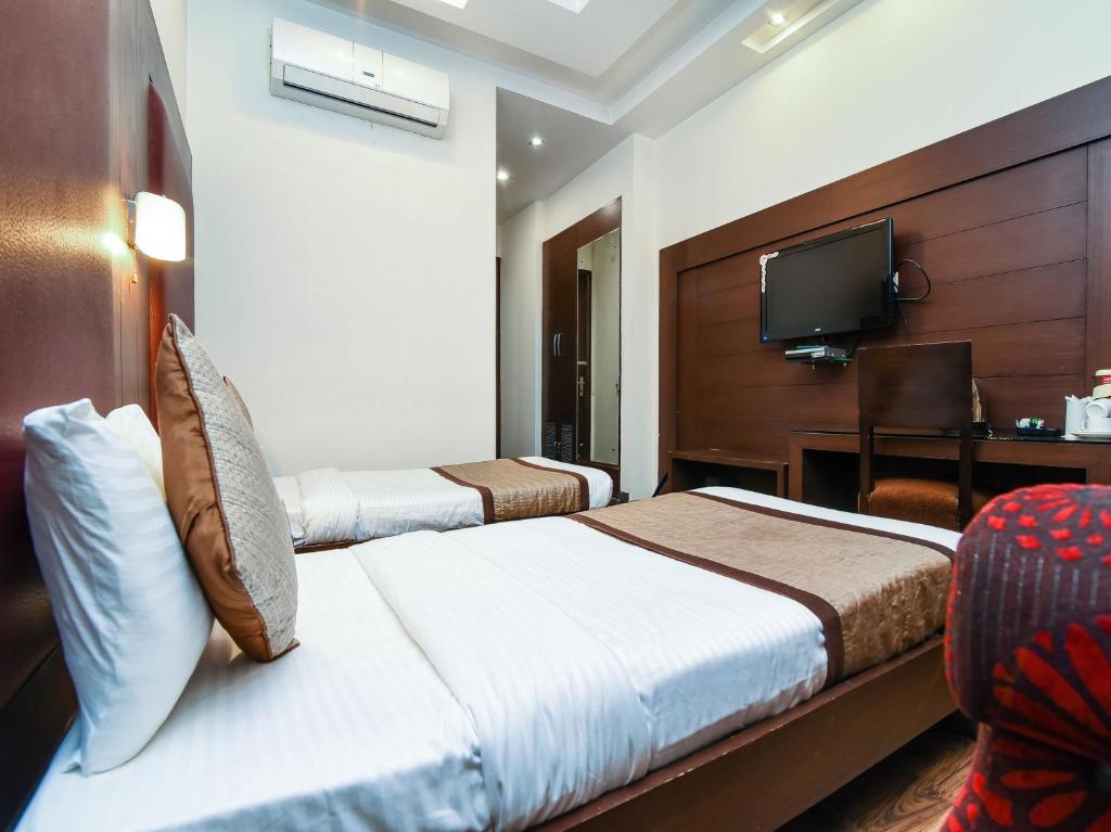 Postel nebo postele na pokoji v ubytování Hotel Haris MG Road Gurugram