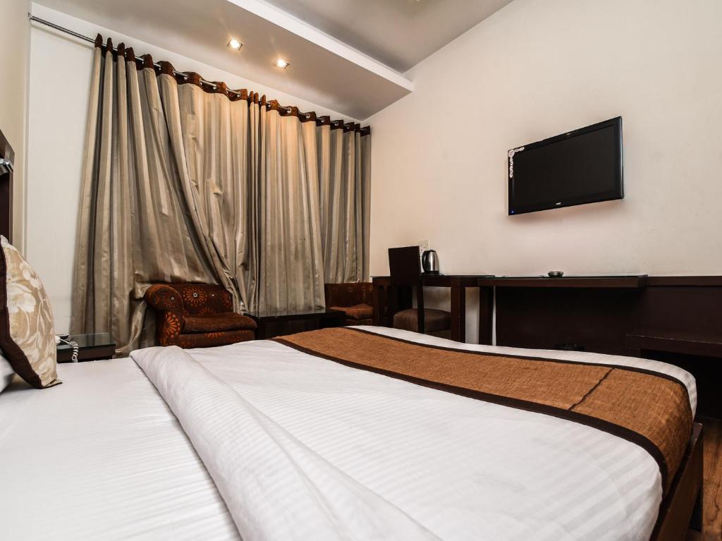 Postel nebo postele na pokoji v ubytování Hotel Haris MG Road Gurugram