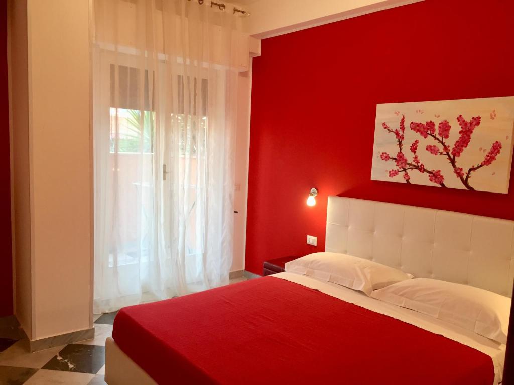 1 dormitorio rojo con 1 cama con pared roja en La casa del Dottore, en Palermo