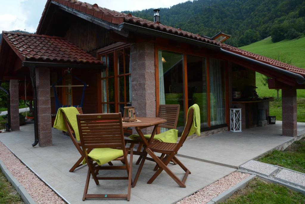 a patio with a table and chairs in front of a house at Studio ALPIKA in Luče