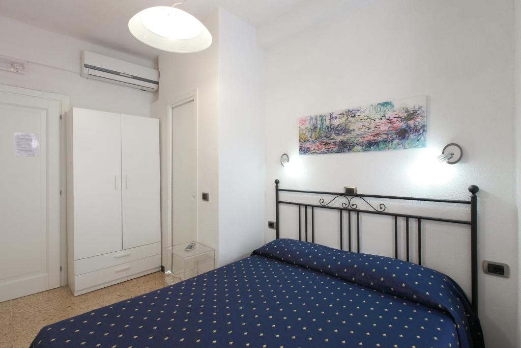 a bedroom with a blue bed in a white room at Albergo Al Carugio in Monterosso al Mare