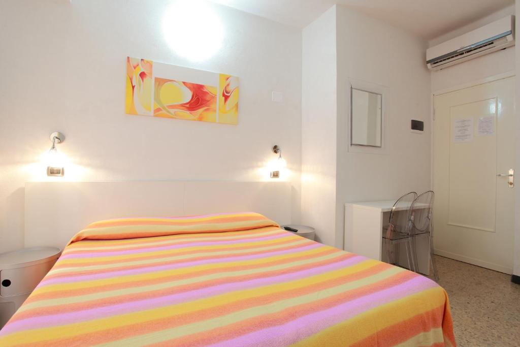 a bedroom with a bed with a colorful striped blanket at Albergo Al Carugio in Monterosso al Mare