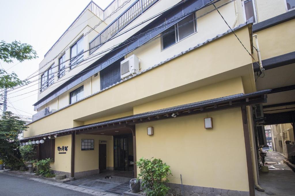a building with a balcony on the side of it at Nogami Honkan in Beppu
