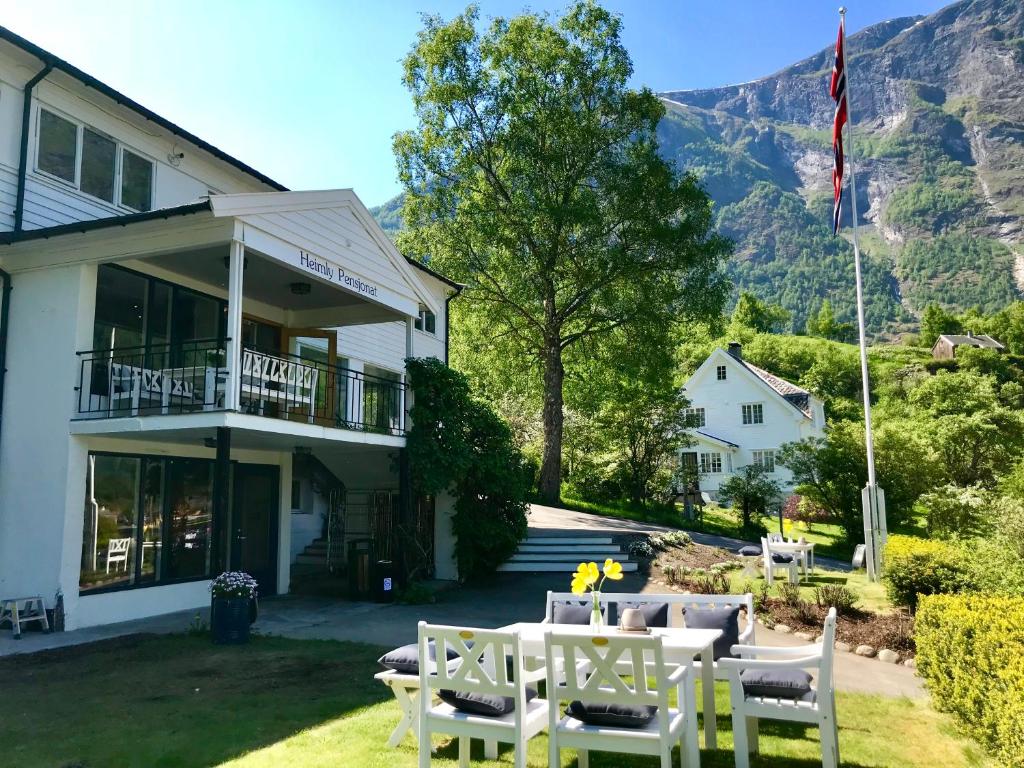 a building with a table and chairs in the yard at Heimly Pensjonat in Flåm