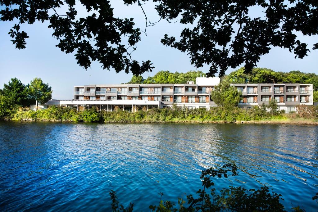 a building on the side of a river at Best Western Plus Hotel les Rives du Ter in Larmor-Plage