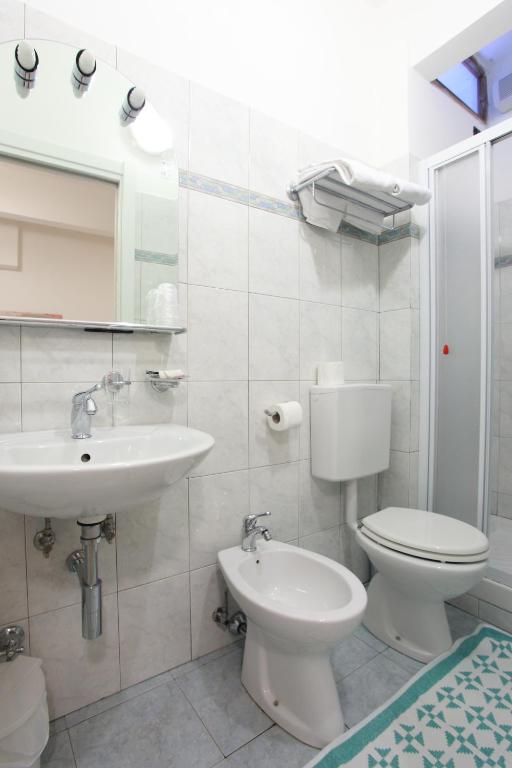 a white bathroom with a toilet and a sink at Albergo Al Carugio in Monterosso al Mare