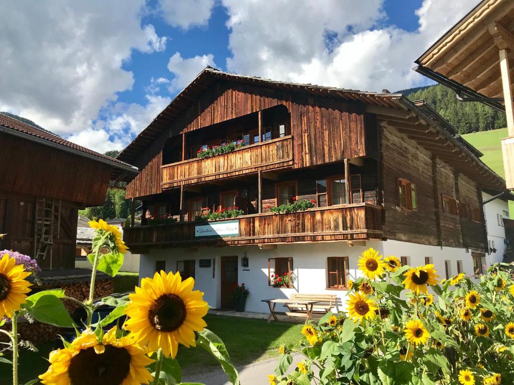 ein Haus mit Sonnenblumen davor in der Unterkunft Landhaus & Schloss Anras in Anras