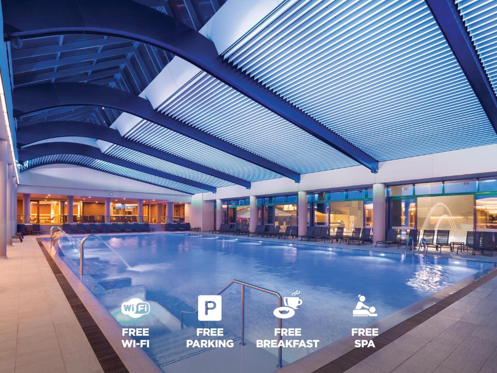 a large indoor swimming pool in a building at Ramada Plaza by Wyndham Bucharest Convention Center in Bucharest