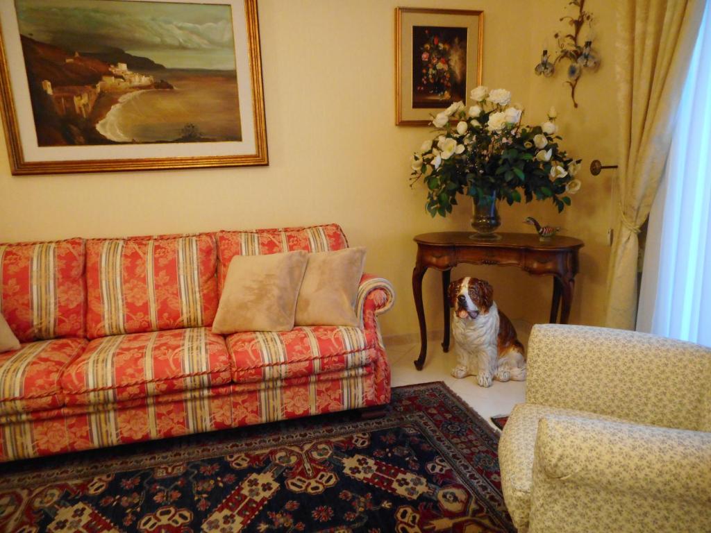 einem Hund, der in einem Wohnzimmer mit einem Sofa und einem Tisch sitzt in der Unterkunft adalgisa house in Catania