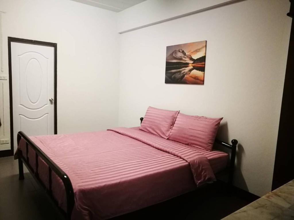 清邁的住宿－Duangdren Apartment，一间卧室配有一张带粉色毯子的床