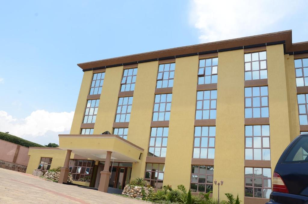 a large yellow building with a lot of windows at Kim Hotel in Kigali