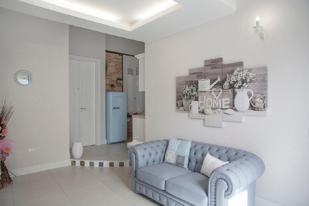 ein Wohnzimmer mit einem blauen Sofa und einem Kühlschrank in der Unterkunft Enry White House in Cagliari