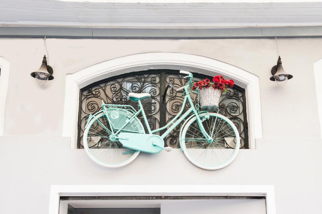 a blue bike hanging on the wall of a house at Hotel Smile & Co Hostal Boutique in Alicante