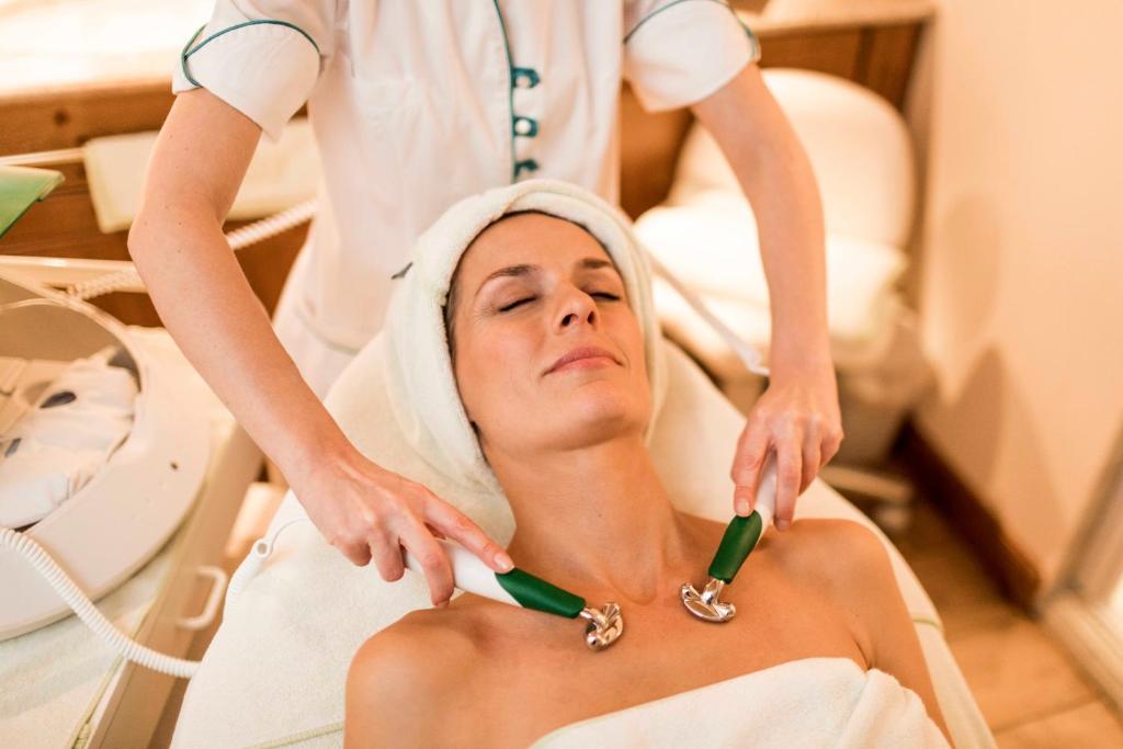 a woman in a hospital room getting her hair cut at Hotel Genziana in Selva di Val Gardena