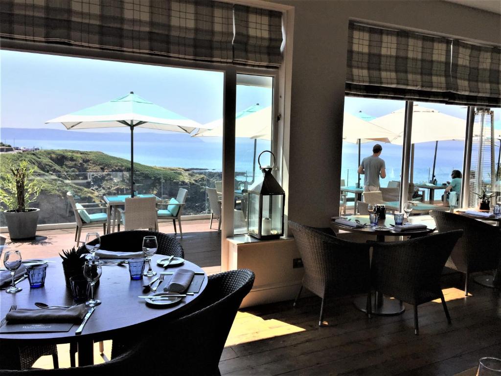 a restaurant with tables and chairs with a view of the ocean at Watersmeet Hotel in Woolacombe