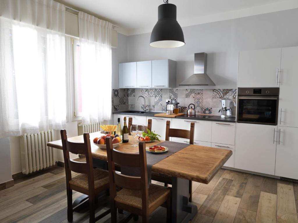 a kitchen with a table and chairs and a kitchen with white cabinets at GINEVRA'S COUNTRY HOME in Due Carrare