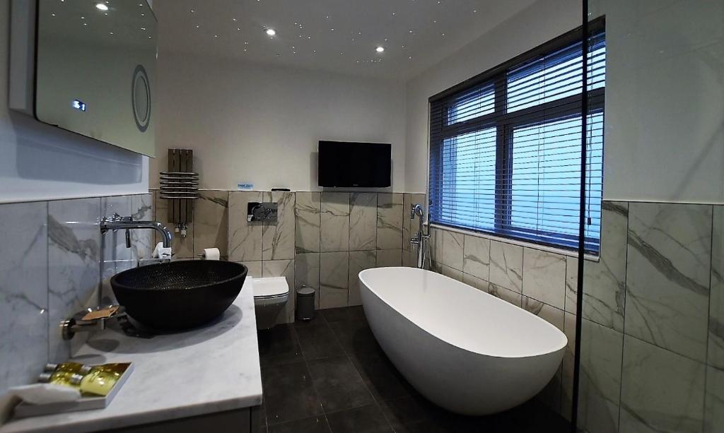 a bathroom with a large bath tub and a sink at Watersmeet Hotel in Woolacombe