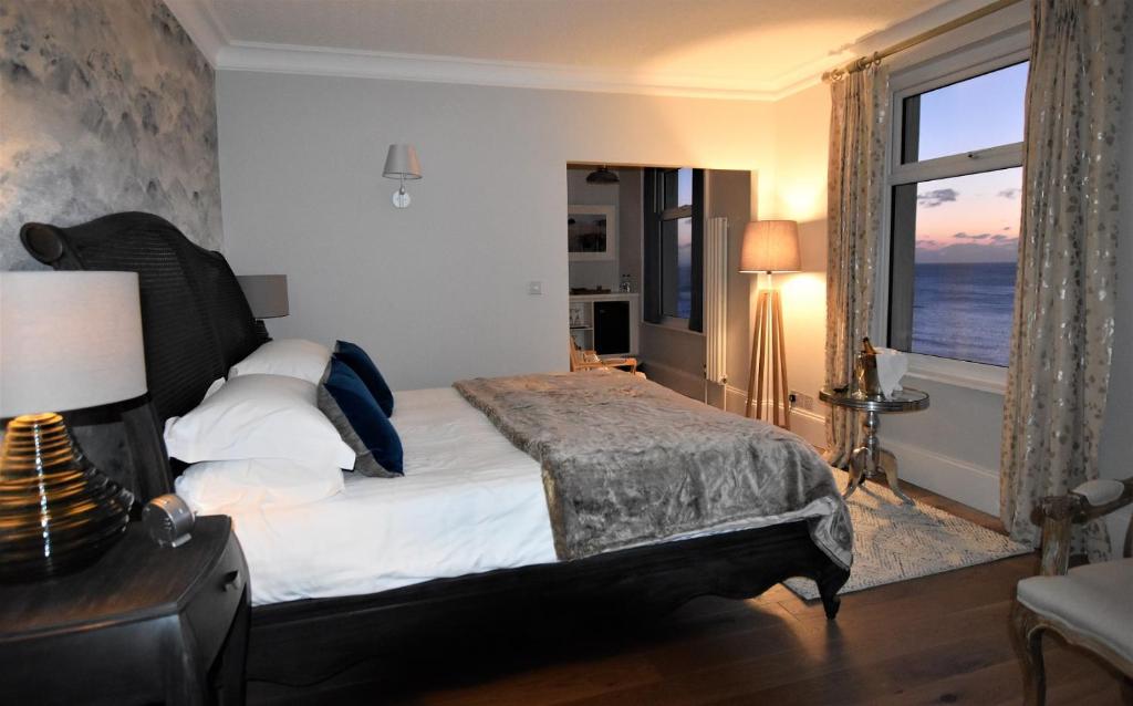 a bedroom with a bed with a view of the ocean at Watersmeet Hotel in Woolacombe