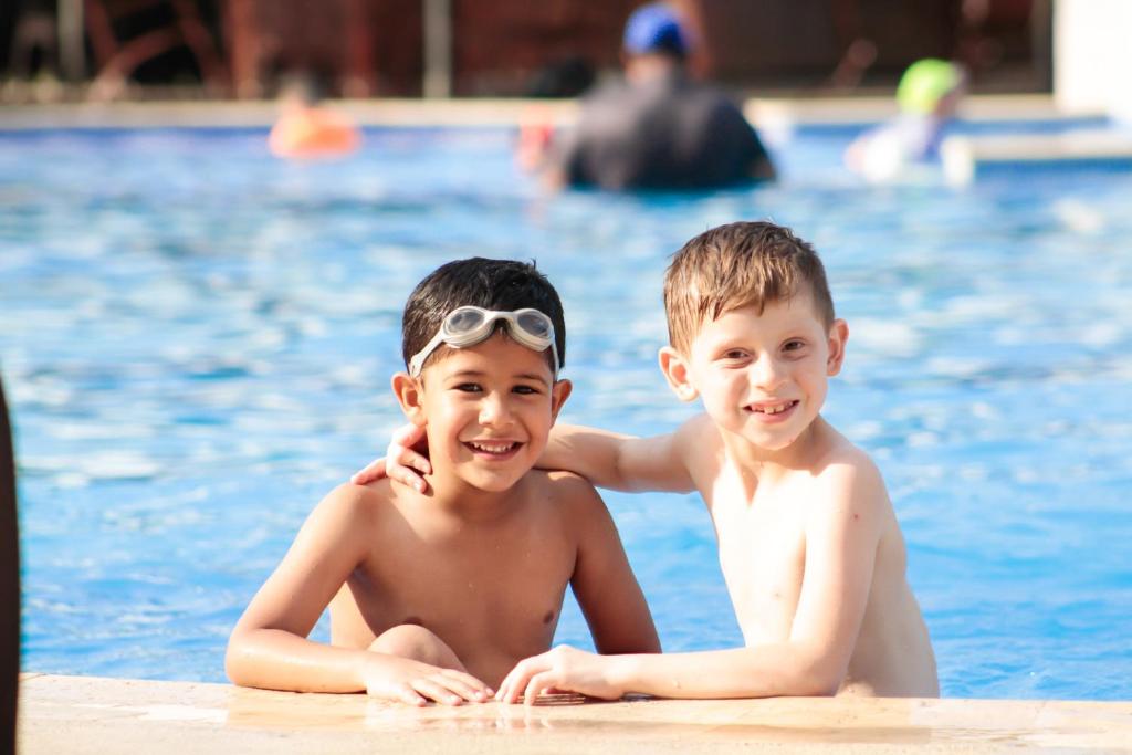 two young boys with goggles on their faces in a swimming pool at Copantl Hotel & Convention Center in San Pedro Sula