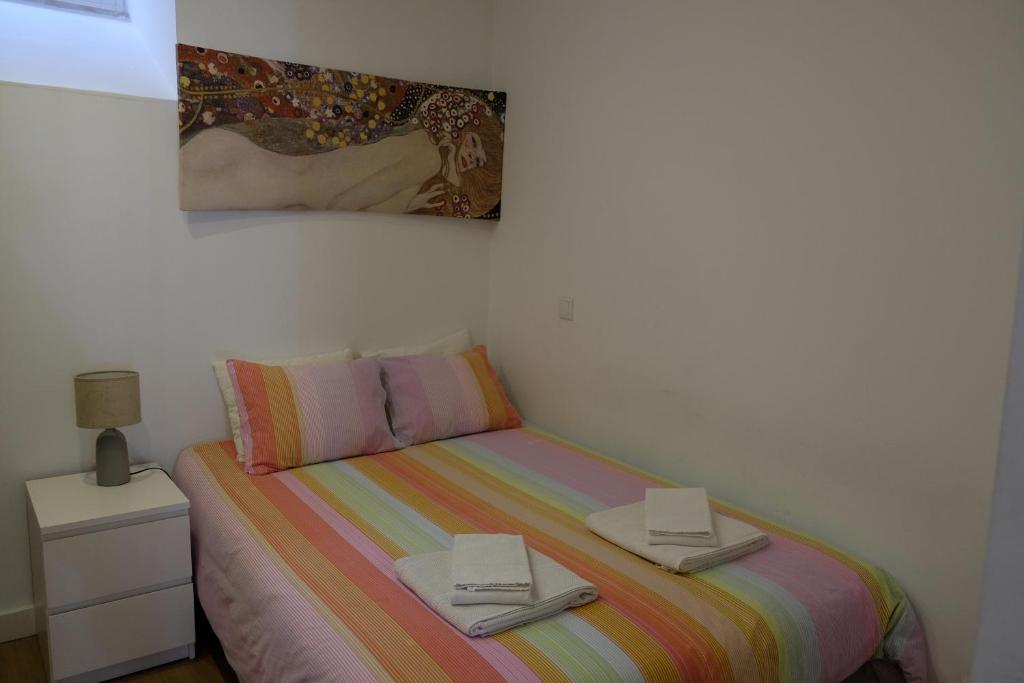 リスボンにあるNice Apartment Bairro Altoのベッドルーム1室(ベッド1台、本2冊付)