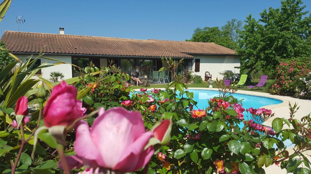 a house with a pool and flowers in front of it at Chambres de Sauviolle in Frontenac