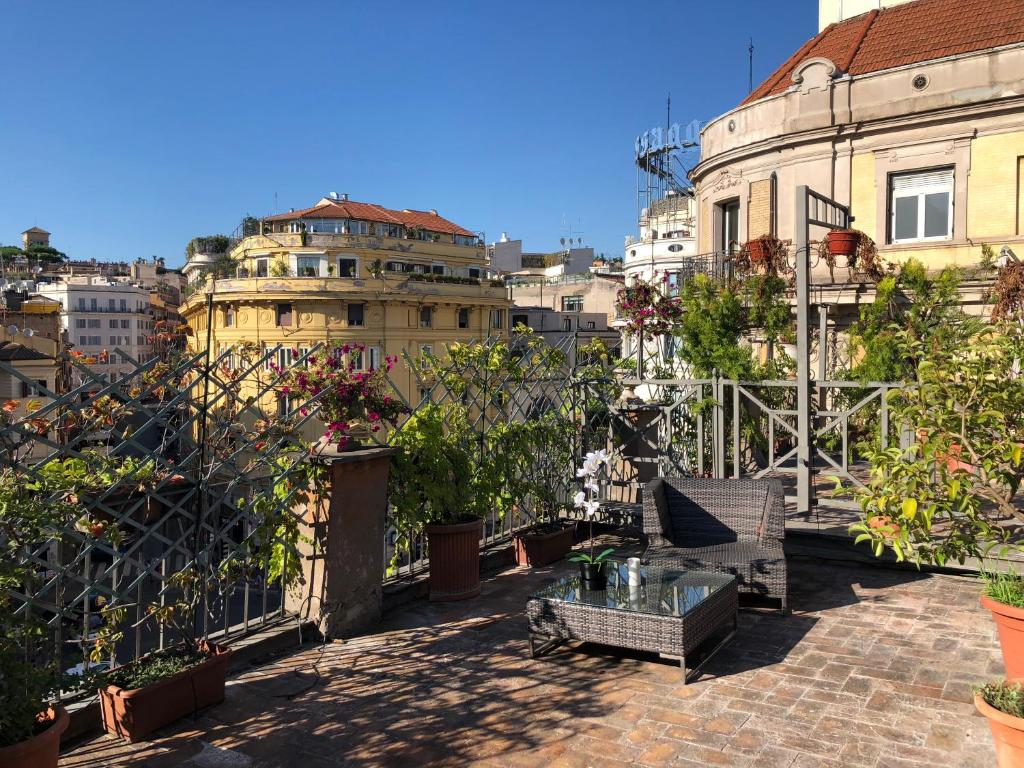 een balkon met een tafel en een aantal planten en gebouwen bij Giuturna Boutique Hotel in Rome