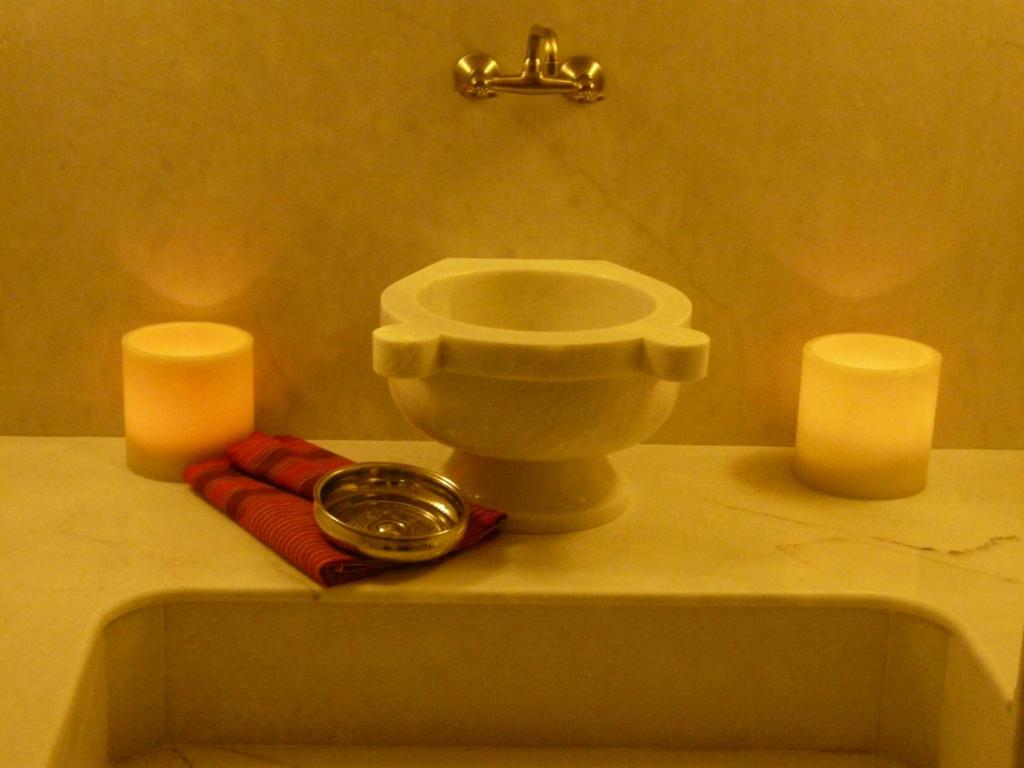 a bathroom with two candles and a clock on a counter at Lycia Hotel in Kaş